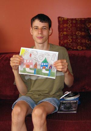 Christian displays his crayon-and-pencil drawing, “My Neighborhood,” which was selected for an exhibit at the Arts Unbound museum in Orange for artists with disabilities. His artwork is a depiction of the SERV Achievement group home where he lives in East Windsor.