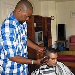 Using barbering tools he bought with funds from The SERV Foundation, Wayne gives a haircut to fellow SERV consumer, Carlos, at SERV Centers’ Serenity House in Mercer County.